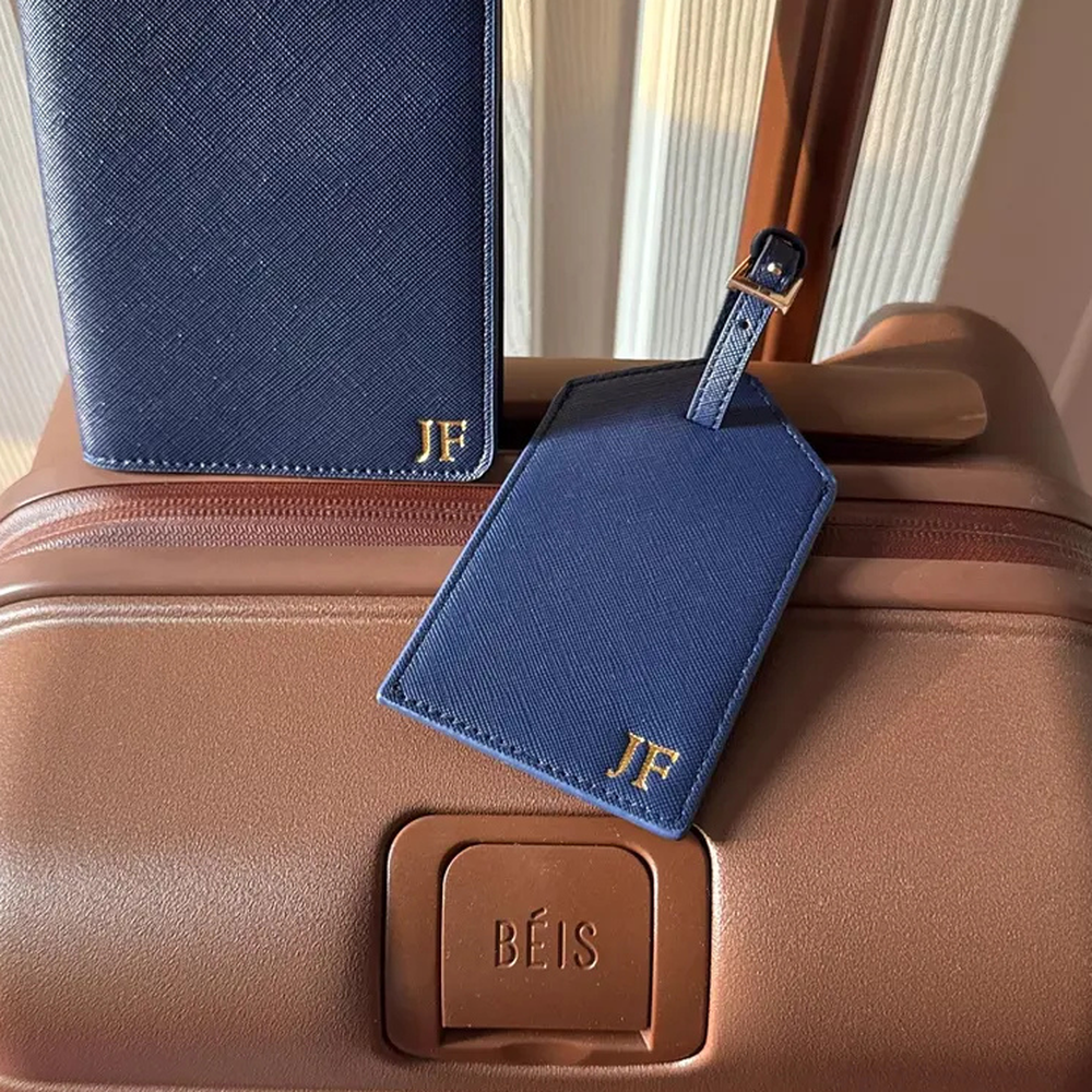 Customer photo of a personalized navy passport cover and tag on luggage
